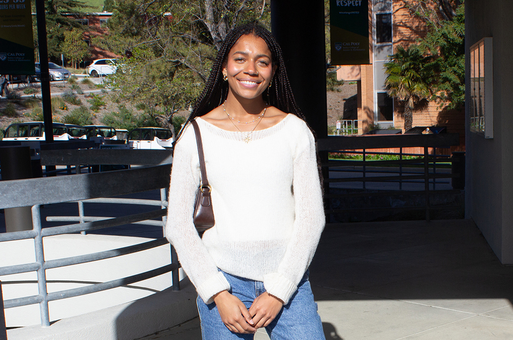 Alea Dosty stands outdoors on the Cal Poly campus in April as she prepares to graduate with a degree in liberal studies