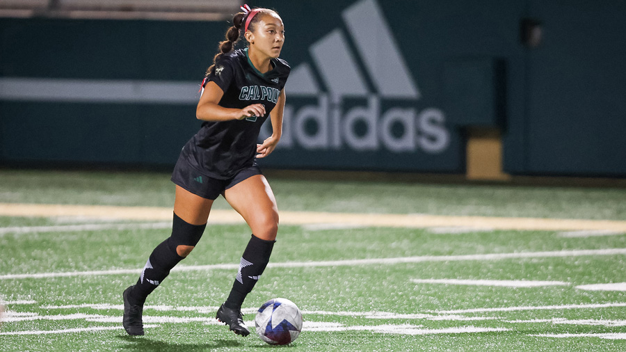 Emma Brown, wearing a Cal Poly soccer uniform, runs across the field dribbling the ball during a women’s soccer match.