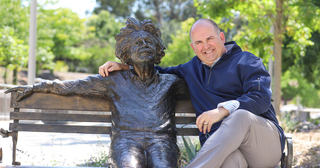 Daniel Kostalnick sits beside the bronze Albert Einstein statue on the Cal Poly Einstein bench.