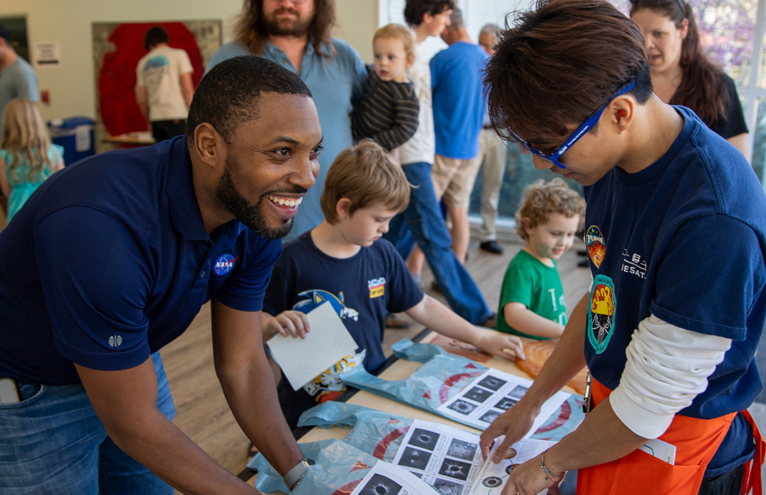 Community members and families participate in hands-on astronomy activities during a Cal Poly event featuring NASA scientists.