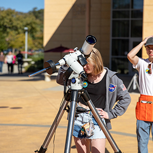 An event participant looks through a solar telescope during a Cal Poly astronomy outreach event.