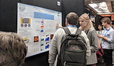 Marissa Dierkes explaining her research poster to a conference attendee.