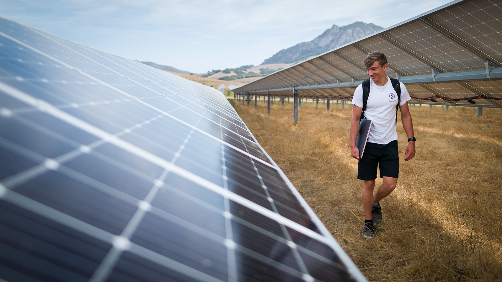 Cal Poly student examining solar panel array.