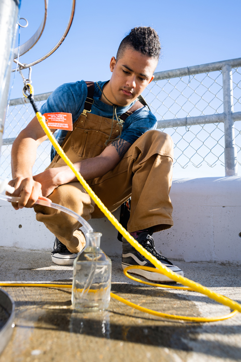 Cal Poly student researcher Jake Roth on a boat taking samples of seawater
