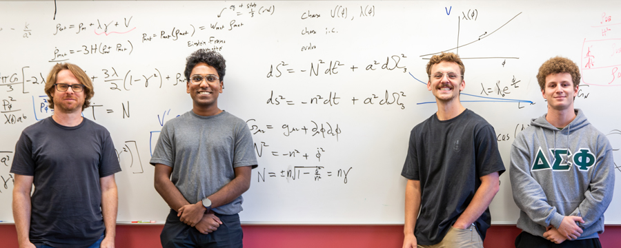 Cal Poly student researchers and professor stand in front of a whiteboard covered with physics and cosmology equations, graphs, and symbols related to spacetime and expansion.