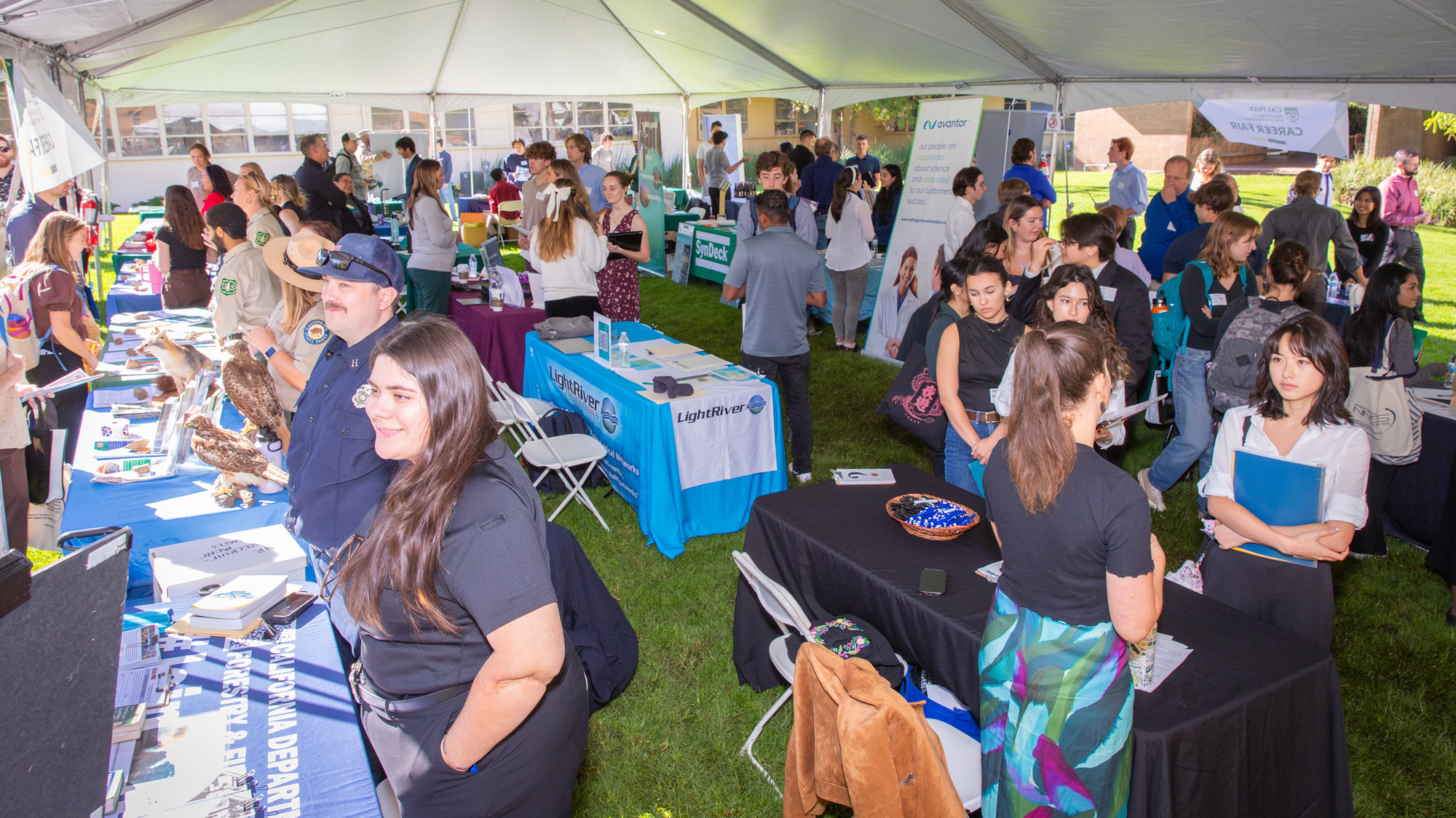 Tent full of employers talking to students at the Bailey College Career Fair event
