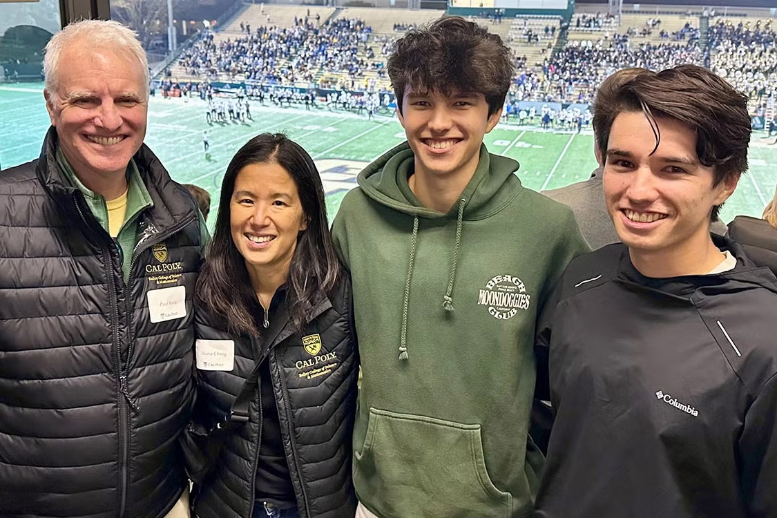 Alumni mentors and donors Paul Keitz and Diana Chung pose with their sons above the Cal Poly football field