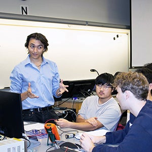 Physics Learning Assistant Seann Brick helps students in lab.