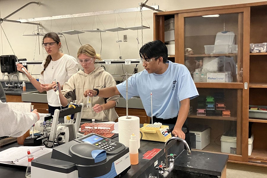 Santos De La Trinidad assists students during a lab experiment in Biology 161.