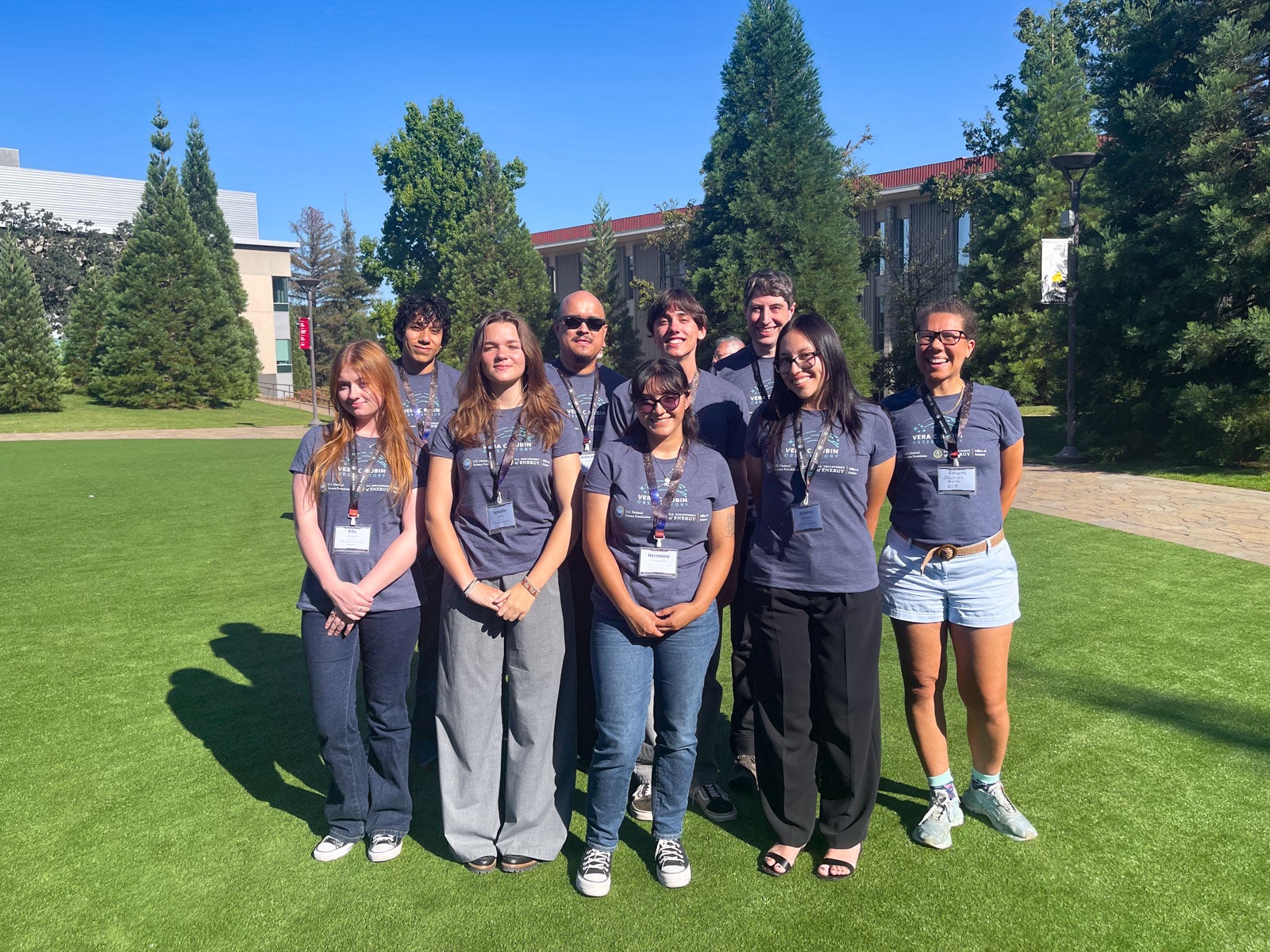 Professor Louise Edwards poses with students from Cal Poly and other universities on a field at the SLAC National Accelerator Laboratory