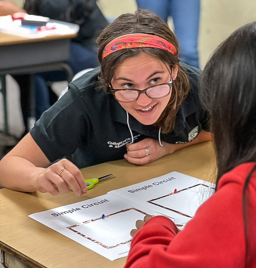 Cal Poly mentor, Sophie Albiani offers encouragement to a young maker as they create a paper circuit at Oceano Elementary School.