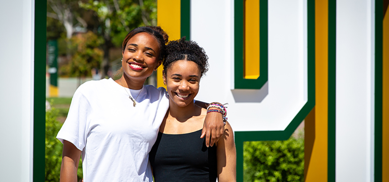 Genesis Glover, a biological sciences major, stands with her sister Maya Glover, an architecture major, on the Cal Poly campus.