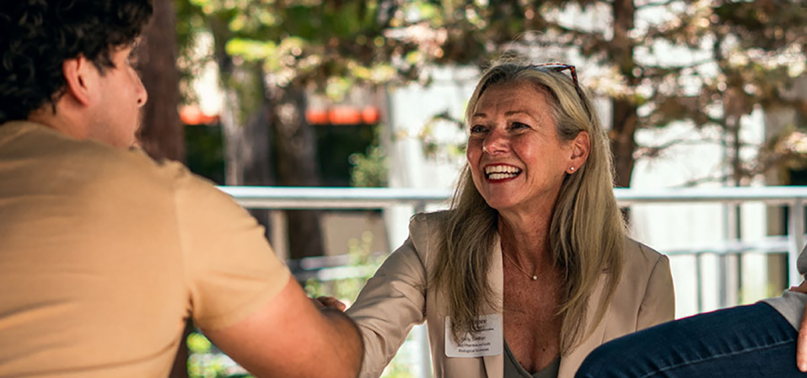 Cal Poly Alumna shaking hands with student at an outdoor mentorship event