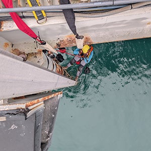 Connor Healy installs equipment at the Cal Poly Pier