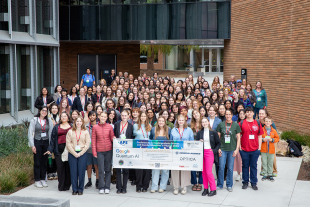 Participants in the 2025 APS Conference for Undergraduate Women and Gender Minorities in Physics gather for a group photo at Cal Poly, holding a conference banner.