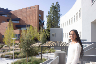 Alea Dosty, a liberal studies major who grew up in foster care, stands outdoors on the Cal Poly campus.