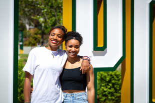 Genesis Glover, a biological sciences major, stands with her sister Maya Glover, an architecture major, on the Cal Poly campus.