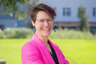 Allison Theobold, Cal Poly assistant professor of statistics, standing for a portrait outside a campus building.