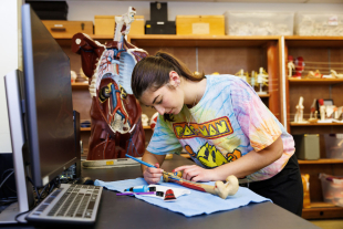 Kinesiology major Kellie Hintzoglou explores the shapes of bones with paint.