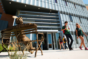 Stock image. Iconic statue foreground. Student exiting William J. Baker Center for Science and Mathematics. 