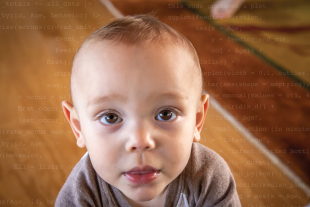 Close-up of a baby looking directly at the camera, with faint data or code text overlaid in the background.