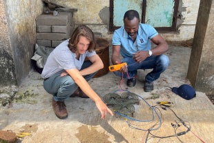 Ryan Marienthal works with Emmanuel, an engineer in Sierra Leone, on solar panels