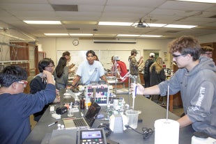 Biological sciences major Santos De La Trinidad works with students in a Biology 161 lab
