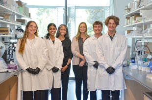 Sarepta Scholars pose with researchers from Sarepta Therapeutics in a lab