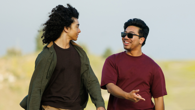 Two Cal Poly students talking on a beach walk.