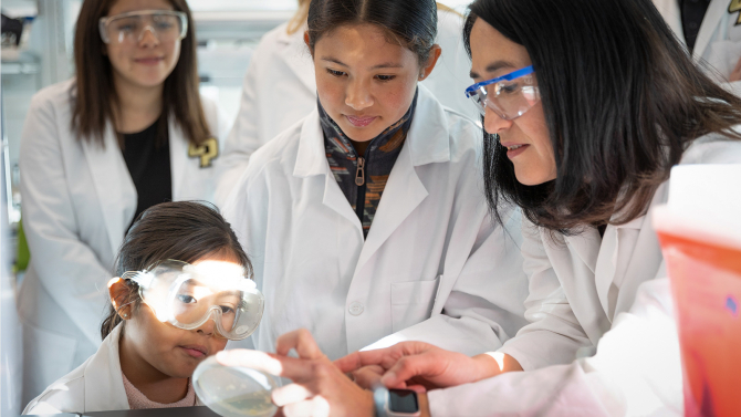 Nuestra Ciencia Professor and students in a lab as part of a CESAME program.