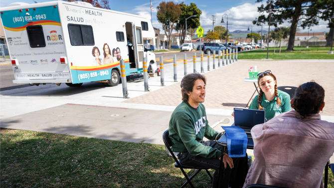 Students speaking with a client of the Mobiile Health Unit.