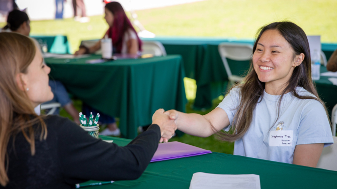 Bailey student shakes hands with a recruiter at the Bailey College career fair