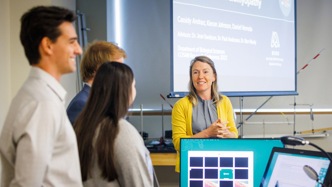Professor with students at a research conference