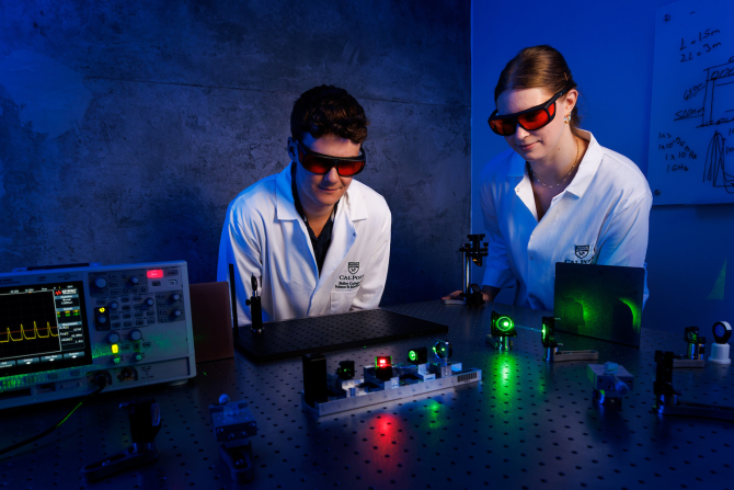 Physics students James Mauck and Hannah Bauer align a green light pump laser used as part of the project to build Cal Poly’s first laser. 