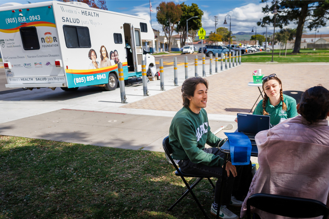 Public health students assist clinic clients as part of their work with Cal Poly’s Mobile Health Unit, providing free care to vulnerable local populations.