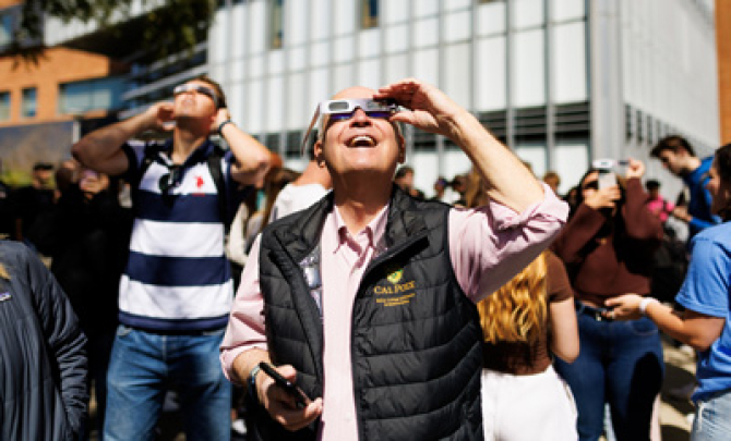 Man looks up at eclipse wearing protective glasses