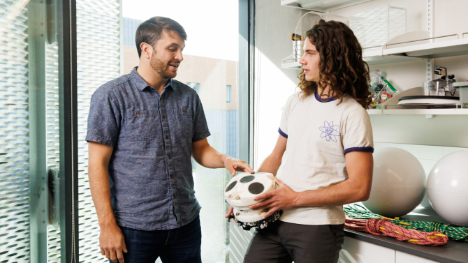 Physic professor at student with equipment used for undergraduate research on extreme ocean temperatures.