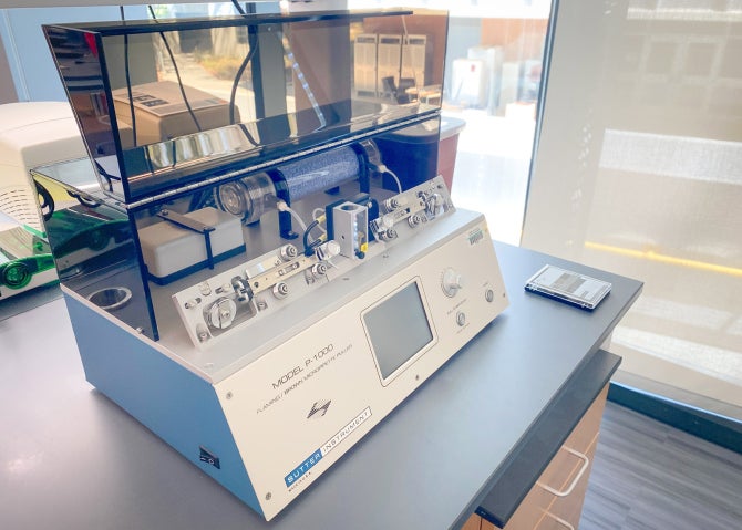 A micropipette puller machine sits on a lab desk